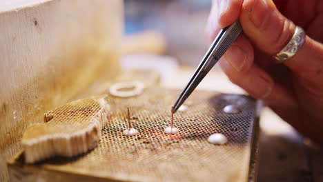 close up of female jeweller soldering earrings in studio