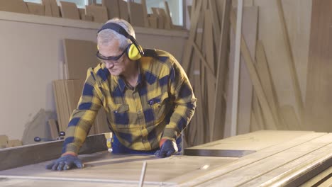 the carpenter is cutting wood in the workshop, working.