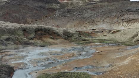 Niedrige-Drohnenüberführung-über-Den-Isländischen-Fluss,-Felsiges,-Bergiges-Gelände-Mit-Nebel-Und-Felsen