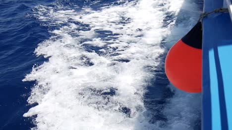 vea las olas desde el costado de un bote a toda velocidad y despiértese en el agua mientras una boya roja cuelga sobre el borde del bote