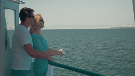 loving couple making mobile selfie during sea tour