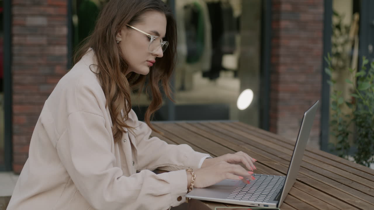 야외에서 노트북으로 일하는 여자