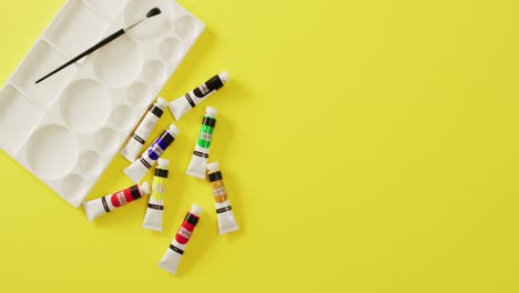 video de pantalones, pincel y paleta con espacio de copia en fondo amarillo