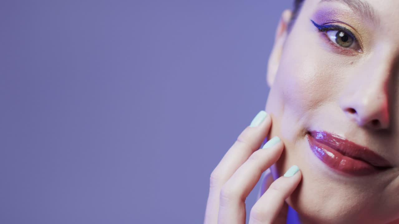 mujer caucásica con cabello rubio y maquillaje tocando su cara, copia espacio, cámara lenta