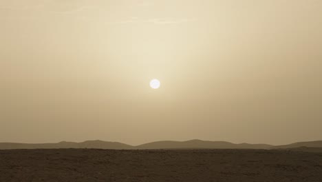 sun shining bright in the sky over the open arid desert area with hills and sand dunes