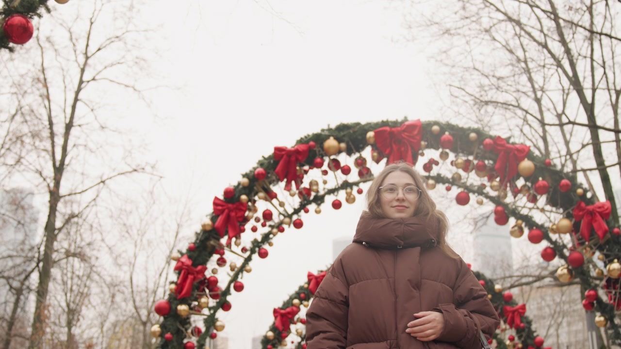 Una ragazza osserva le decorazioni. Un'osservatrice guarda gli ornamenti stagionali con delizia e ammirazione. La ragazza esamina simboli festivi finemente decorati con evidente fascino e gioia.