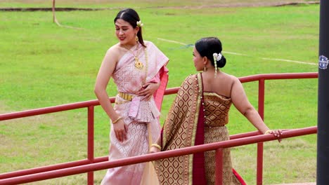 two women in traditional thai attire posing