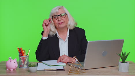 thoughtful senior businesswoman making notes, writing down thoughts with pen into notepad notebook