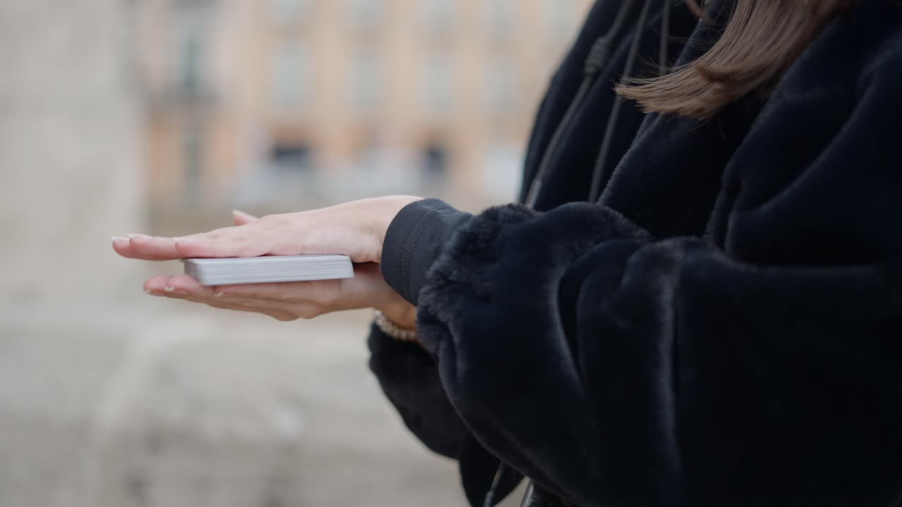 Woman holding a deck of cards outdoors