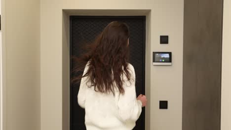 woman using intercom system at door