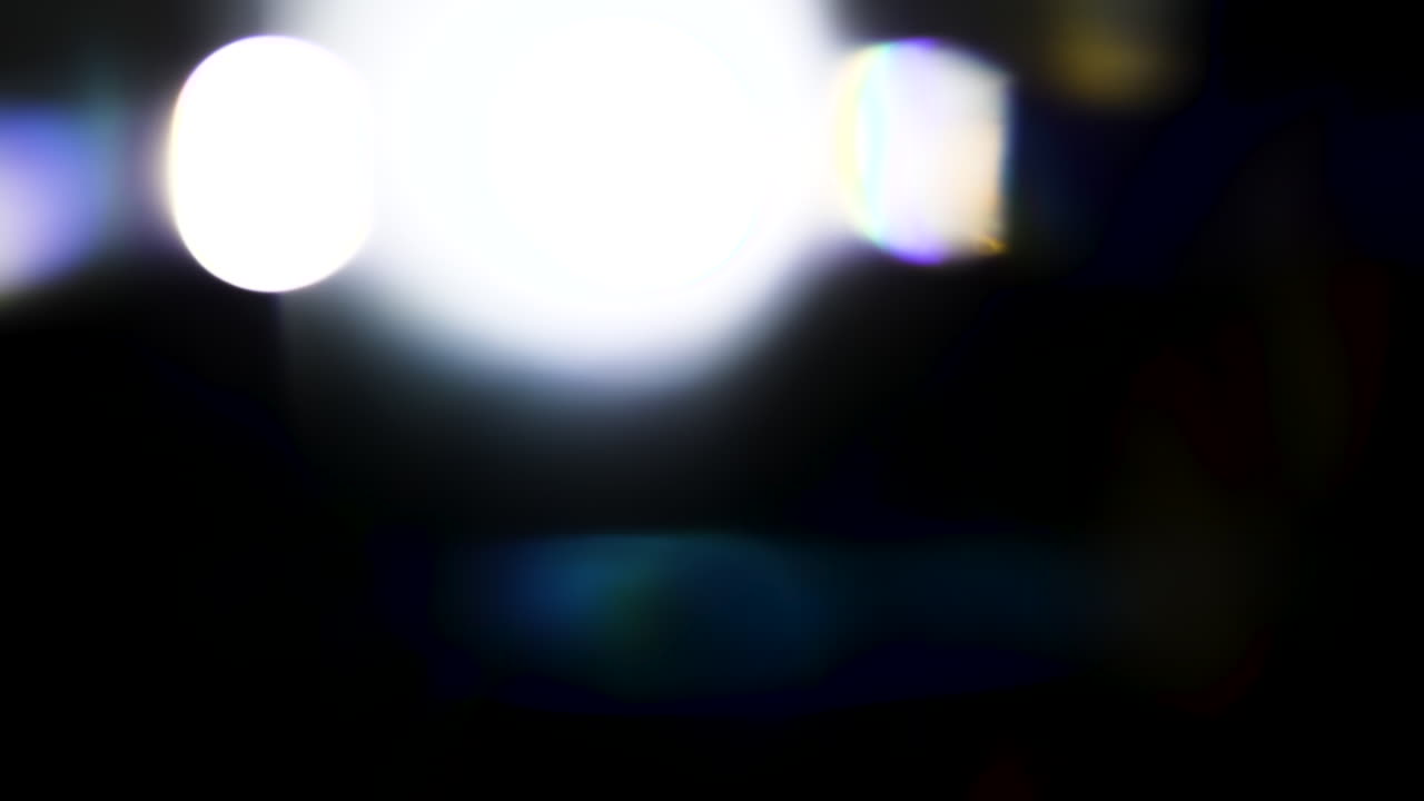 Beautiful, stunning light reflections and anamorphic blue streaks shot on black with high-end cinema anamorphic lens as a background, light leak overlays or transitions for editors