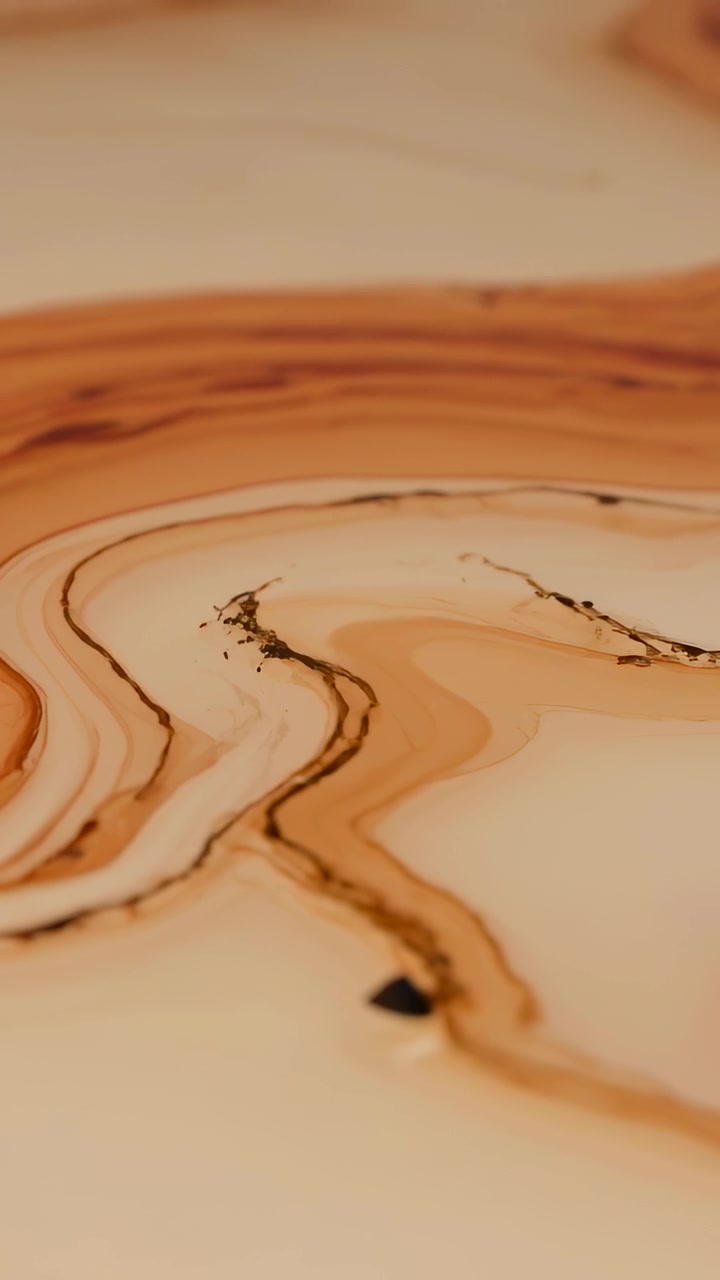 Vertical video: Moving camera revealing marble cream canvas, showing brown veins, dots and red disc