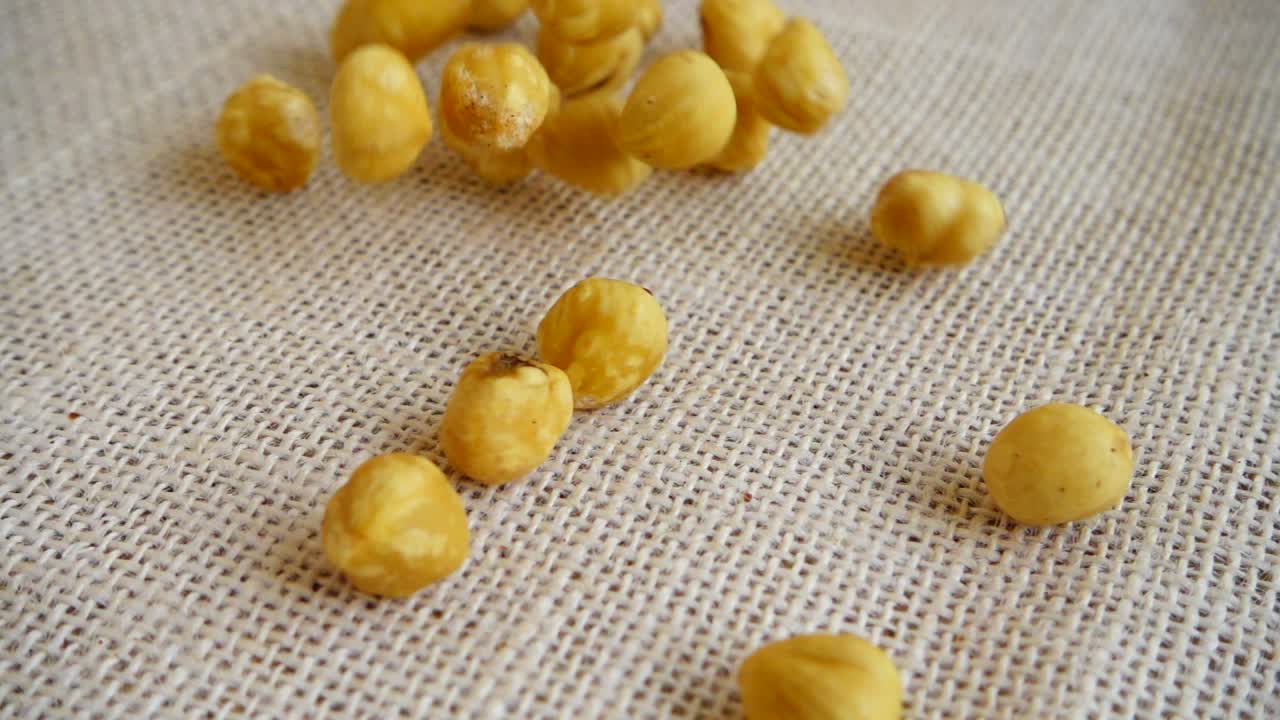 Nocciole. Riprese mentre cadono su un sacco. Movimento rallentato