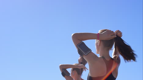 two athletic friends stretching on promenade before run