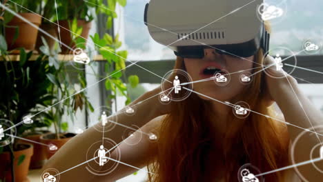 Animation-of-network-of-connections-with-icons-over-caucasian-woman-with-vr-headset