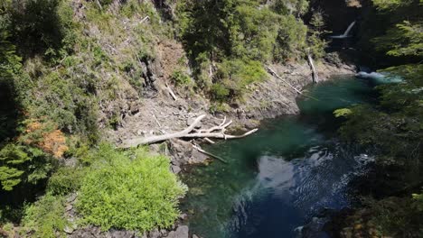 Aerial-flight-showing-hidden-lush-waterfall-with-stream-in-Patagonia-during-sunlight-in-summer,Argentina