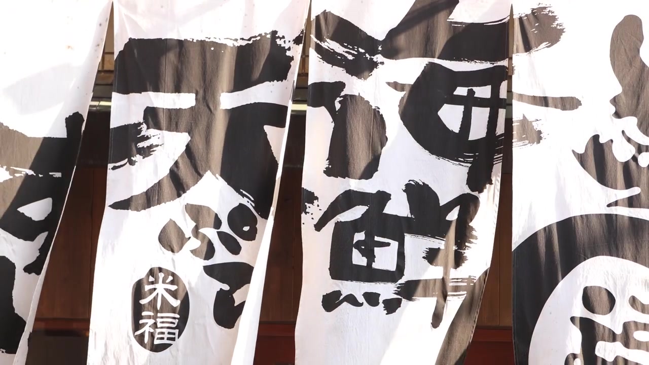 File di botti di sake decorative, coperte da audace calligrafia giapponese, creano un dettaglio culturale grafico nell'area storica di Gion a Kyoto, evocando le tradizioni shintoiste e il patrimonio della produzione locale.