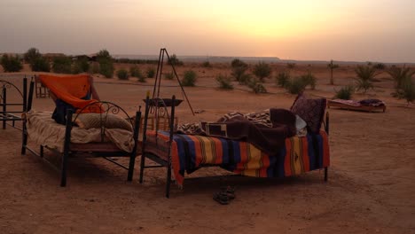 marroquíes durmiendo en la cama fuera de la carpa en medio del desierto del sahara, áfrica, marruecos