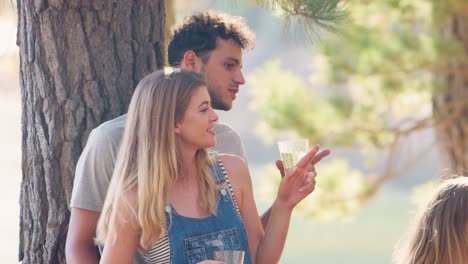 young couple talking to friends by a lake