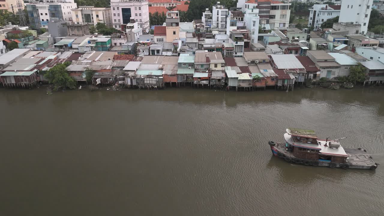 Boat and Barge on a River with Urban Waterfront Houses