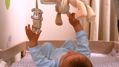 Baby-playing-with-mobile-in-his-crib