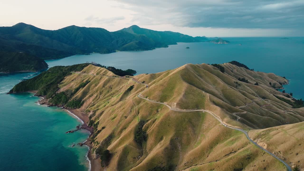 뉴질랜드 남섬 아오테아로아의 말보로 사운드 (marlborough sounds) 의 놀라운 투르코이즈 바다 물과 함께 테 아우미티 (te aumiti) 프랑스 패스 (french pass) 의 반도에 있는 휘어지는 도로의 풍경적인 항공 전망