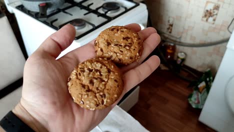 dos galletas de avena en la mano del hombre