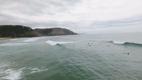 Cinematic-flying-of-surfers-surfing-along-coast-of-East-London-South-Africa-aerial