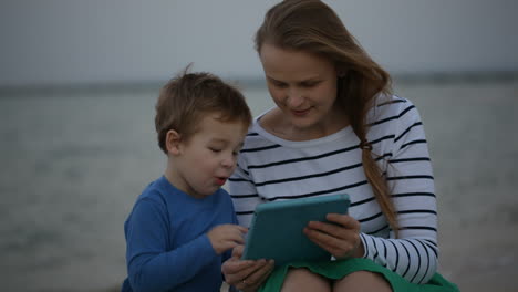 Mutter-Und-Sohn-Mit-Pad-Am-Meer