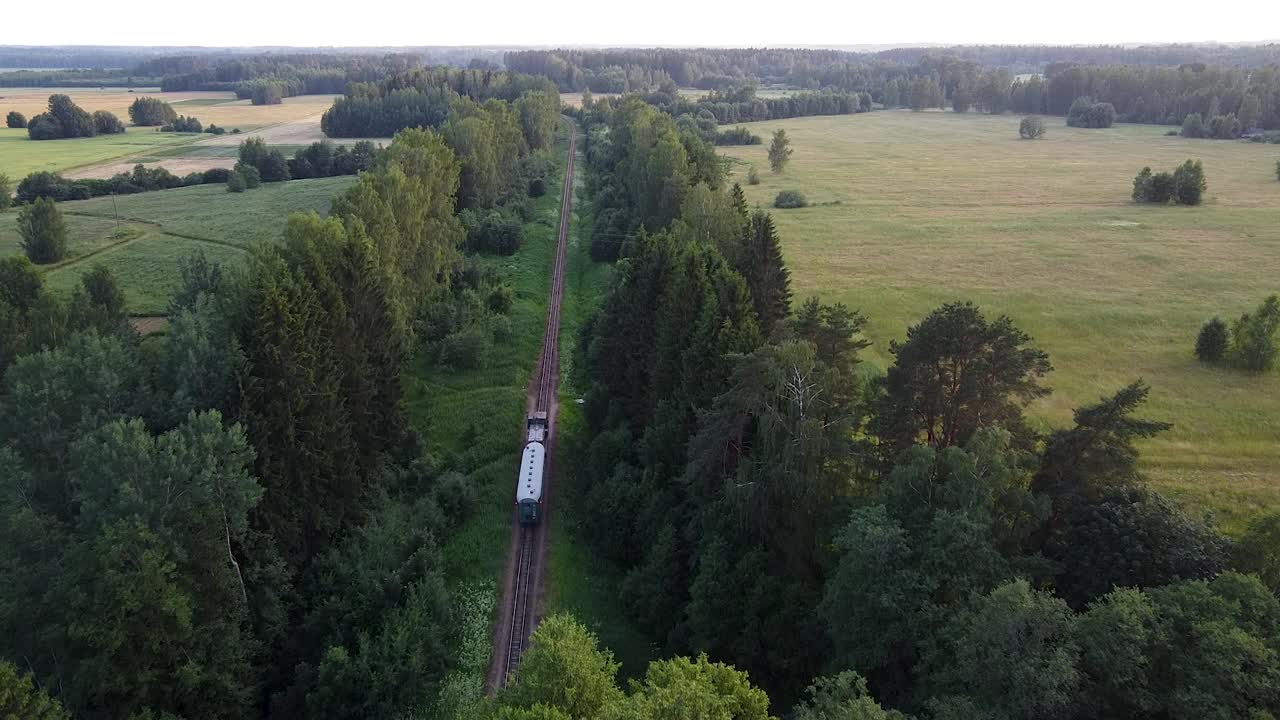tren de vía estrecha moviéndose a través de la vista aérea del paisaje rural