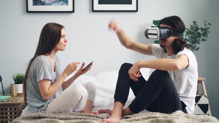 Coppia che sperimenta la realtà virtuale insieme a letto