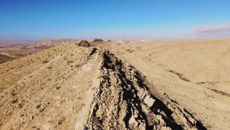 vuelo aéreo sobre un excursionista masculino caminando a lo largo de la línea de la cresta en el desierto de negev ubicado en israel