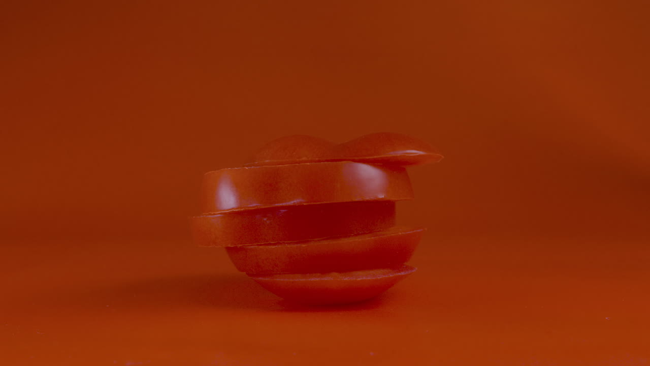 rodajas de tomate caen una encima de la otra y luego se convierten en un tomate entero - video de stop motion