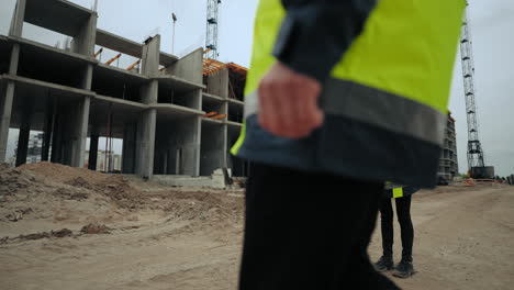 un capataz profesional y una joven arquitecta están discutiendo el plan de construcción de un objeto de construcción