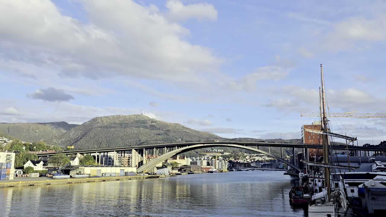 Wide static shot of morning traffic on Puddefjords Bridge with reflections in calm Damsgardsundet water