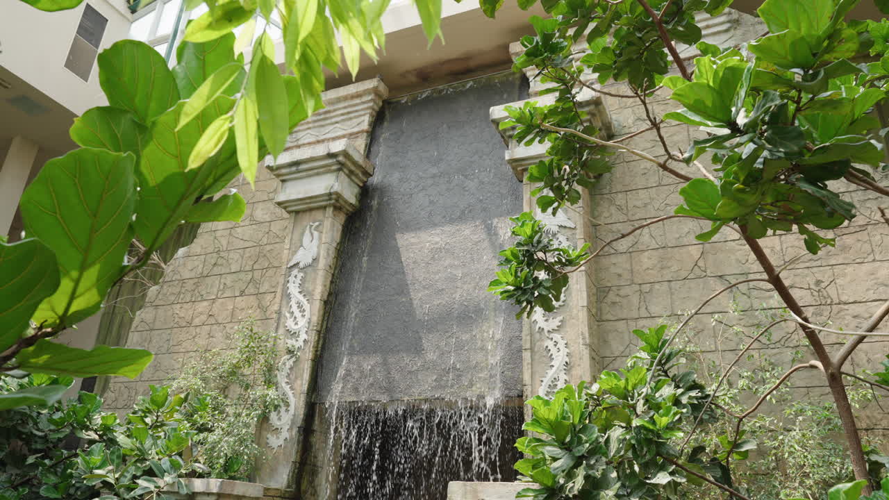 Indoor Waterfall with Tropical Plants and Ornate Stonework
