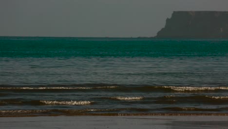 Static-shot-of-gentle-waves-washing-up-on-green-beach