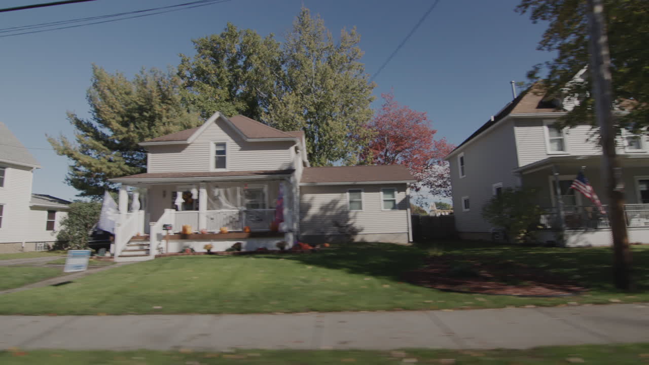 Drive along a typical street of an American town on a clear autumn day. Side view