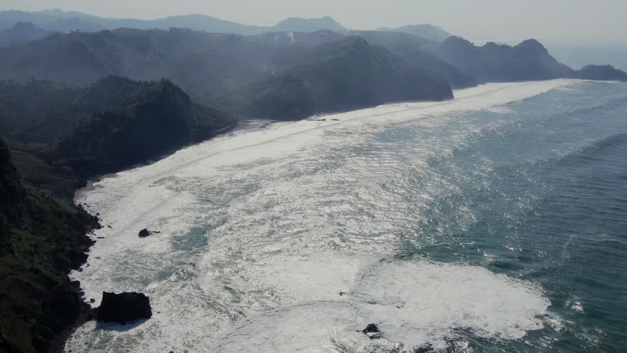 산과 함께 안개가 많은 이른 아침에 열대 해안선 해변, 공중 전망