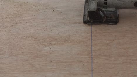 construction worker cutting wood planks with circular electric saw outdoors