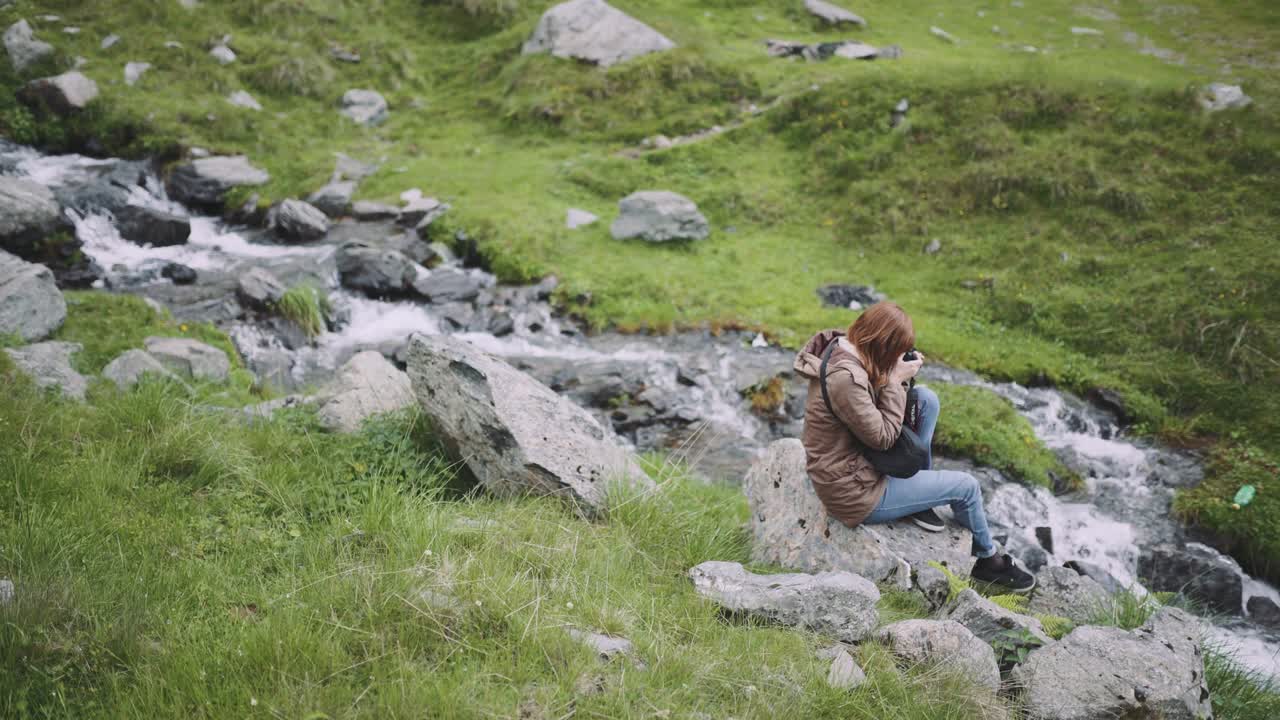 젊은 여성 하이커가 사진 카메라로 산을 등반합니다. 트랜스파가라산, 루마니아의 카르파티아 산맥
