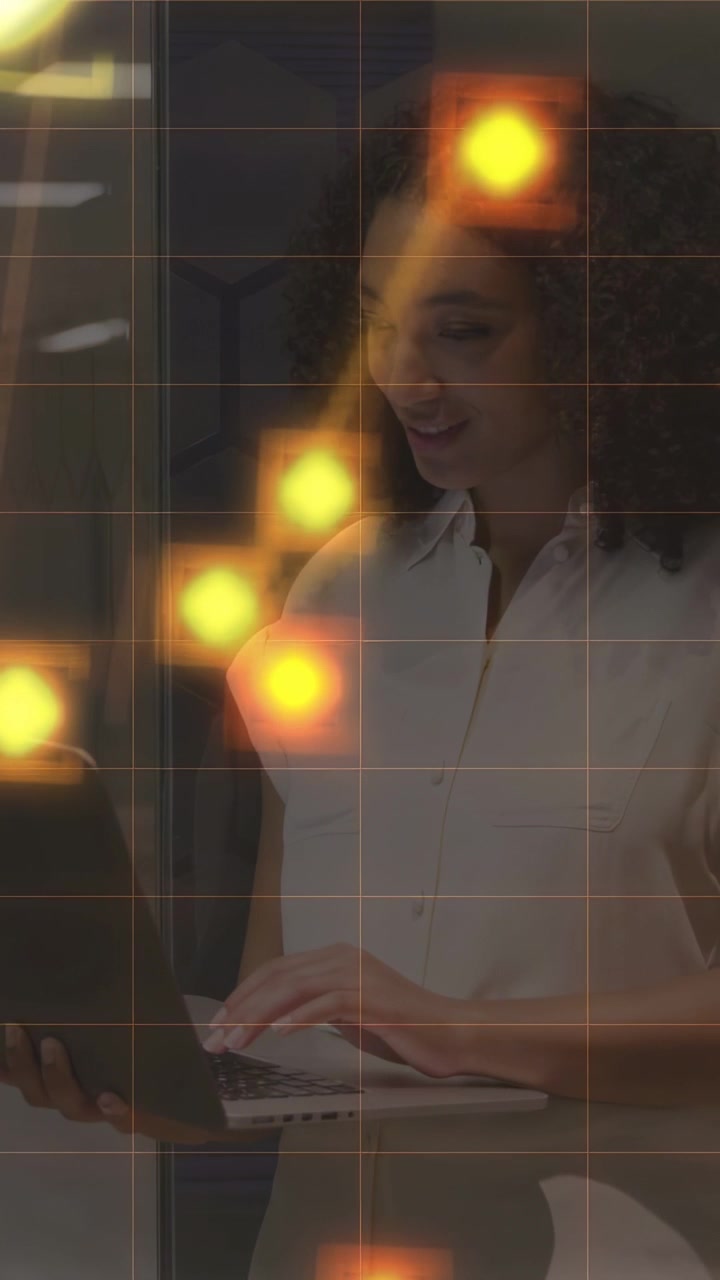 Vertical video: Woman holding laptop, typing in tech office, causing glowing nodes for analysis
