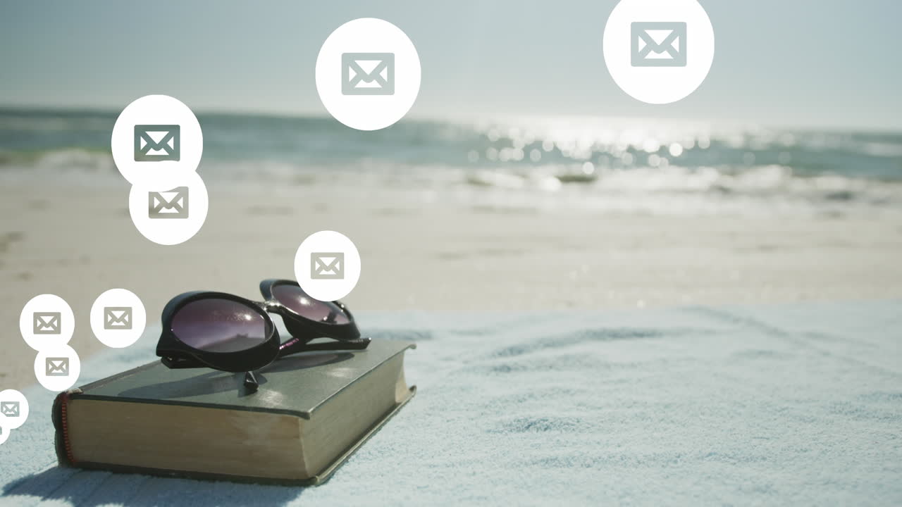 Animation af netværk af ikoner for sociale medier og e-mail over en bog og solbriller på en strand.