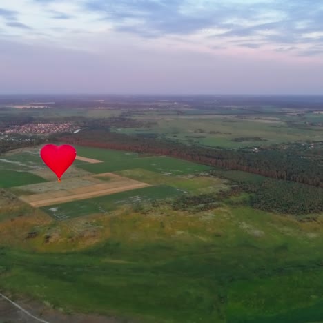 red air balloon in love heart shape. panoramic view on nature landscape and beautiful hot air balloon. bright aerostat flying over the fields.