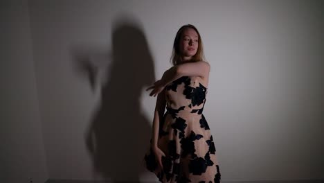 young woman in beige dress dancing in studio