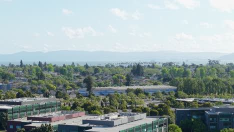 Panning aerial view from a drone, showcasing the roof tops of businesses in the Mariner Square neighborhood of Alameda California.
