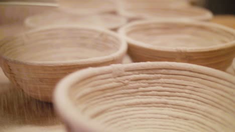 bakery powdering flour over ferment baskets