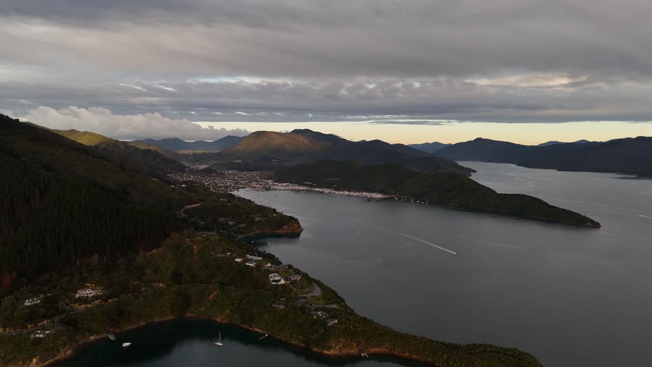 This high-quality 4K drone footage captures the tranquil beauty of sunrise over Picton Port, illuminating the harbor and the ships in New Zealand's picturesque South Island