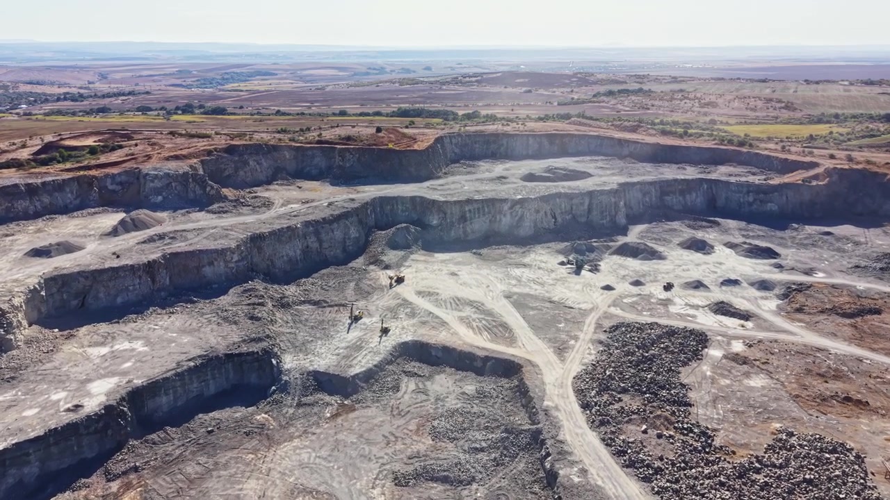 Granite quarry located in a rural area with machinery and workers engaged in quarrying activities