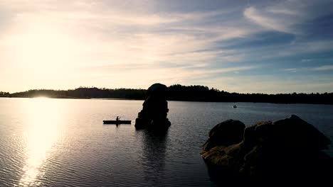 beautiful colorado sunrise on a lake with a silhouette of a canoe against the rising sun